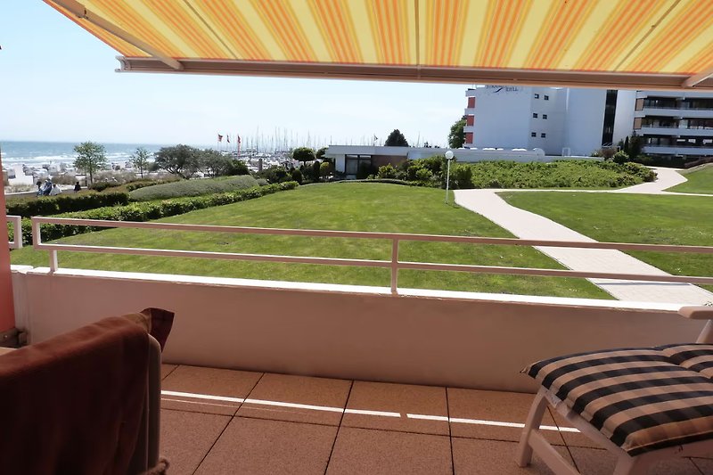 Eigener Balkonbereich mit Gartenmöbeln und Sonnenmarkise. Blick auf Yachthafen.