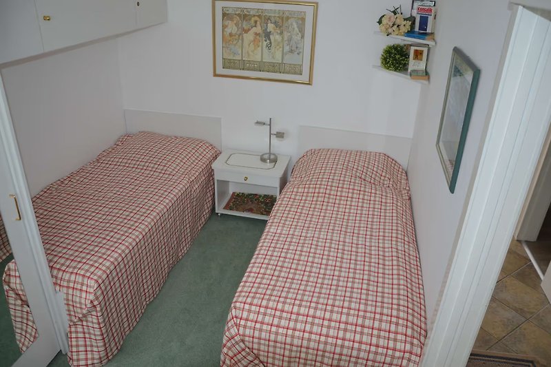 Schlafzimmer mit bequemen Betten gestellt als Einzelbetten.