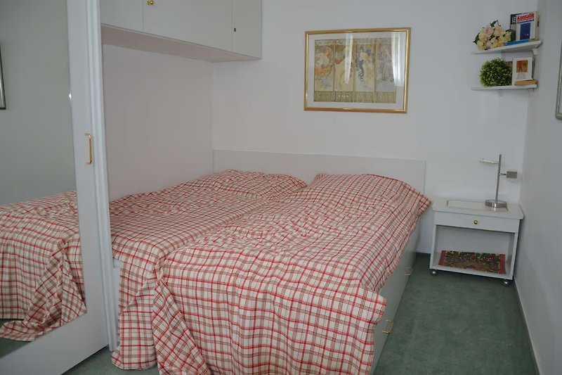 Schlafzimmer mit bequemen Betten gestellt als Doppelbett.