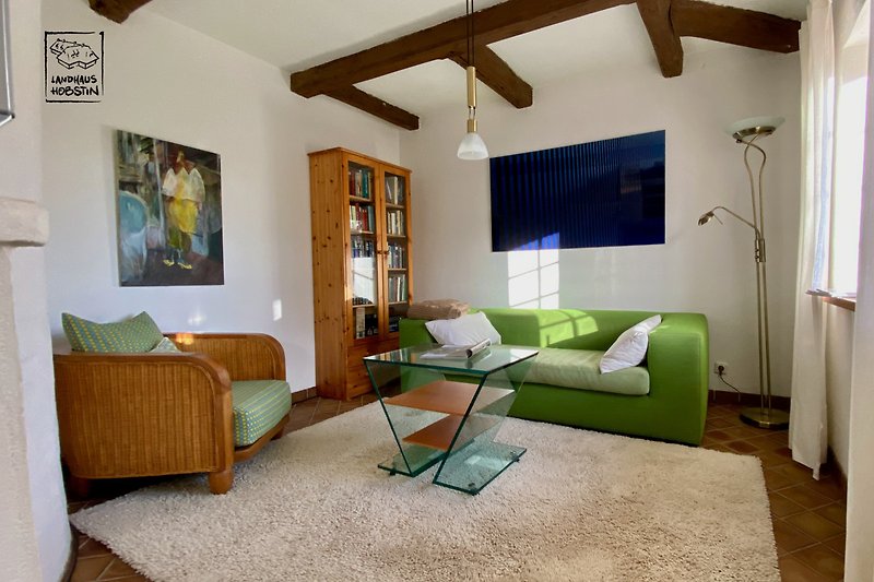 Gemütliches Wohnzimmer mit bequemer (Schlaf-) Couch und stilvollem Tisch.
