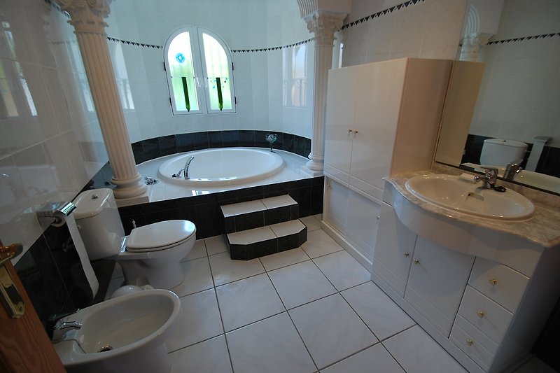 großzügiges Bad-en-Suite mit großer Rundbadewanne und WC