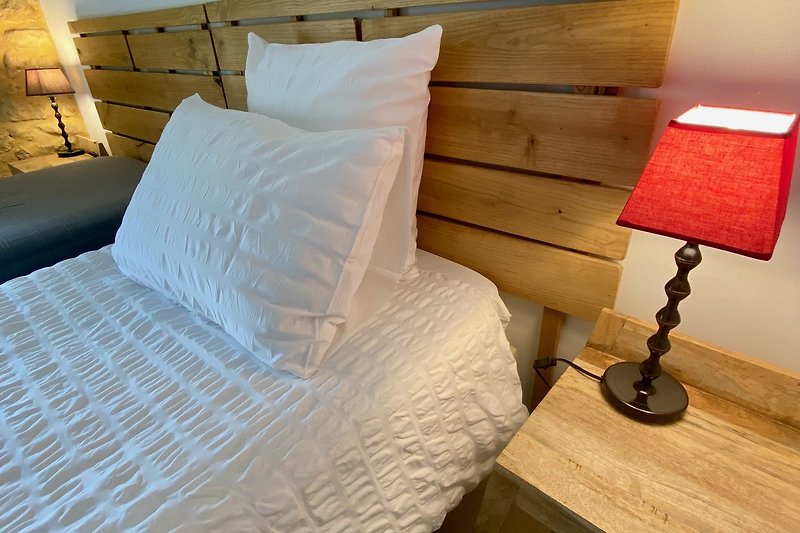 Das Kopfteil des Bettes wird lokal aus Kastanienholz aus dem Limousin hergestellt.