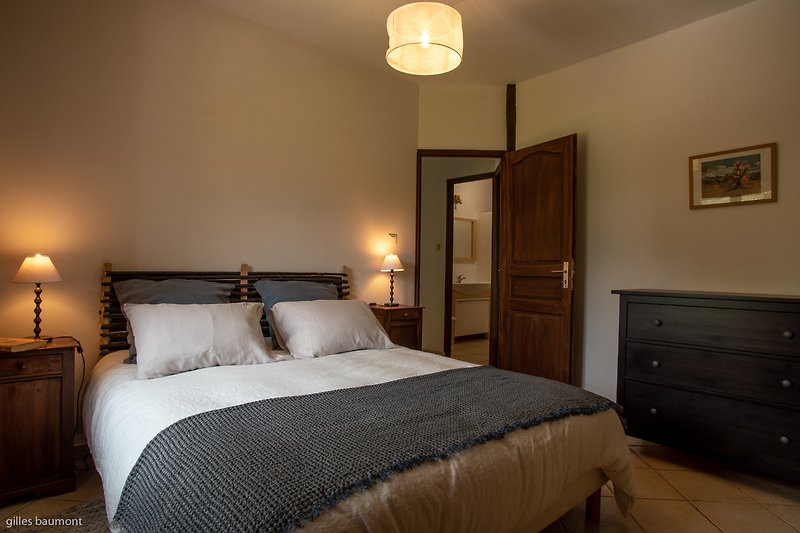 Stilvolles Schlafzimmer mit hoch Qualität queen-size Bett, schöner Beleuchtung und Holzmöbeln.