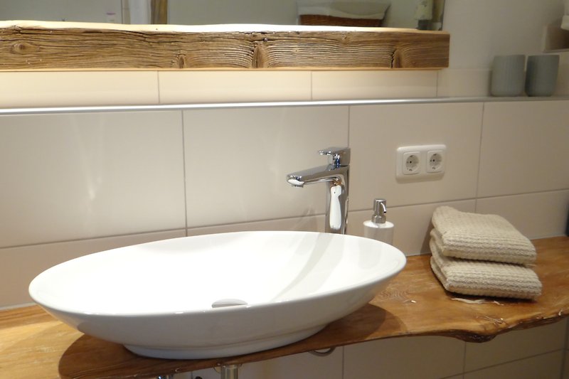 Modernes Badezimmer mit eleganter Keramik und Holzdetails.