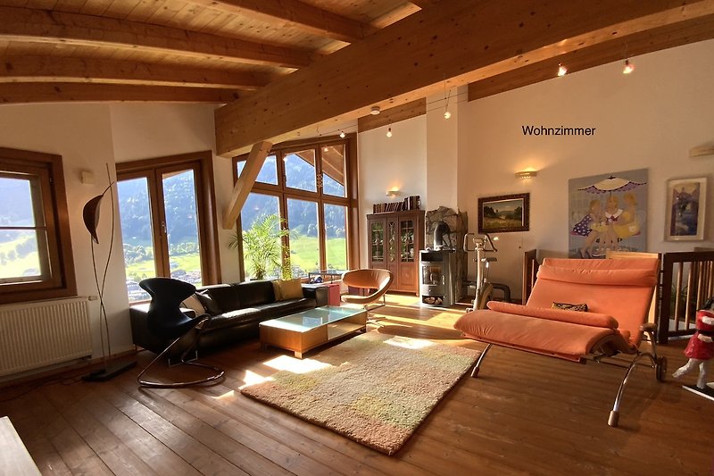 Ein stilvoll eingerichtetes Wohnzimmer mit großen Fenstern und Holzmöbeln.
