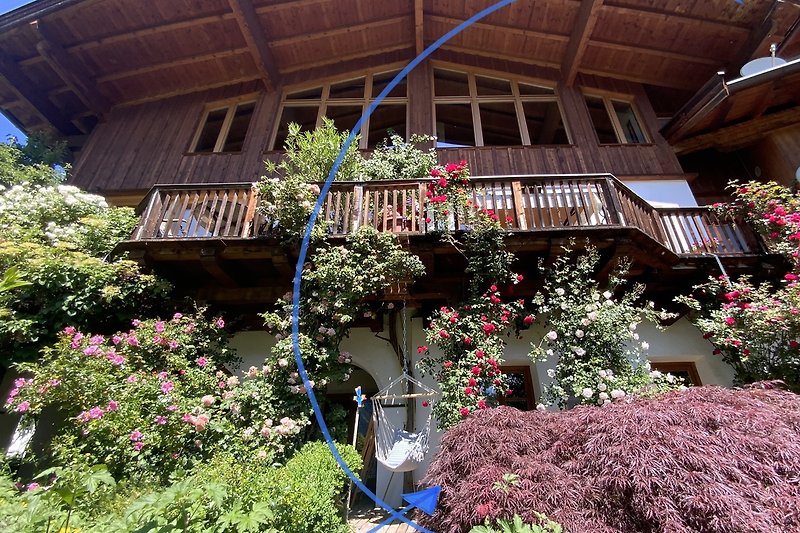 Ein charmantes Haus mit blühenden Pflanzen und malerischer Landschaft.