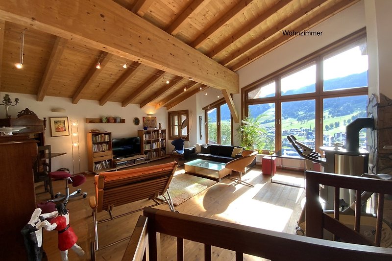 Ein stilvoll eingerichtetes Wohnzimmer mit Holzmöbeln und großen Fenstern.