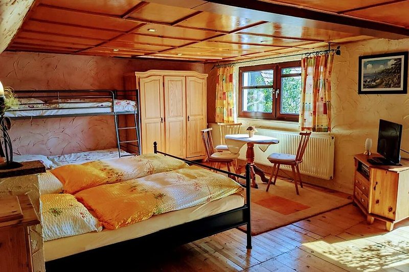 Schlafzimmer II: Gemütlichkeit mit Holzmöbeln, einem Doppelbett und einem Etagenbett im Obergeschoss