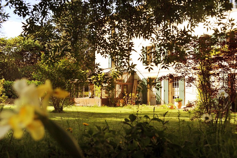 Une maison de campagne avec un jardin verdoyant et une belle vue sur la nature.
