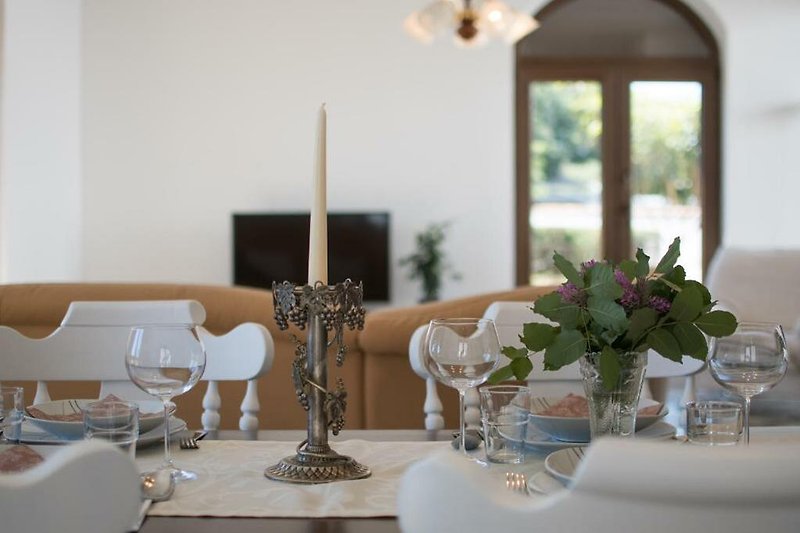 A beautifully decorated dining room with elegant tableware and candlelight.