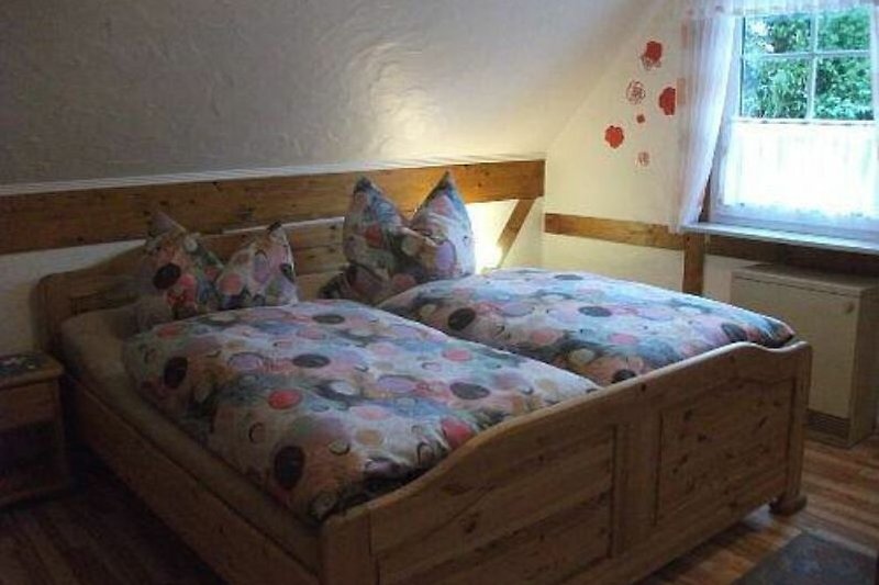 Gemütliches Schlafzimmer mit Laminatboden und bequemem Bett.
