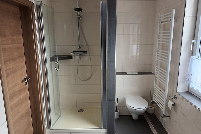Modernes Badezimmer mit stilvoller Dusche und Fenster.