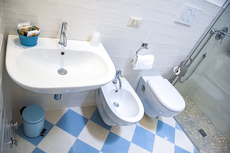 Un bagno moderno con lavandino viola e piastrelle di ceramica.