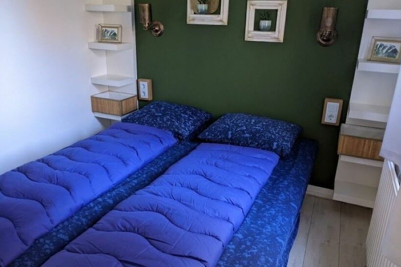 Gemütliches Schlafzimmer mit Holzbett und Fensterbehang.