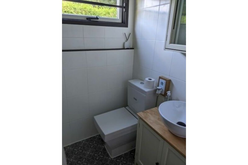 Schönes Badezimmer mit Holzschrank, Spiegel und Fliesen.