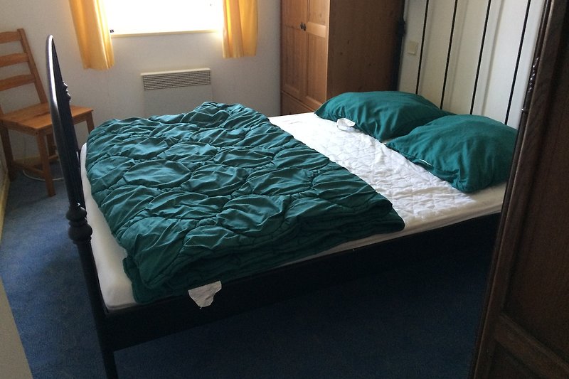Gemütliches Schlafzimmer mit bequemem Bett (140 x 200 cm), Kleiderschrank und Kommode.