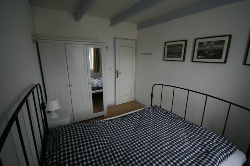 Gemütliches Schlafzimmer mit bequemem Bett (160 x 200 cm) und großem Kleiderschrank.
