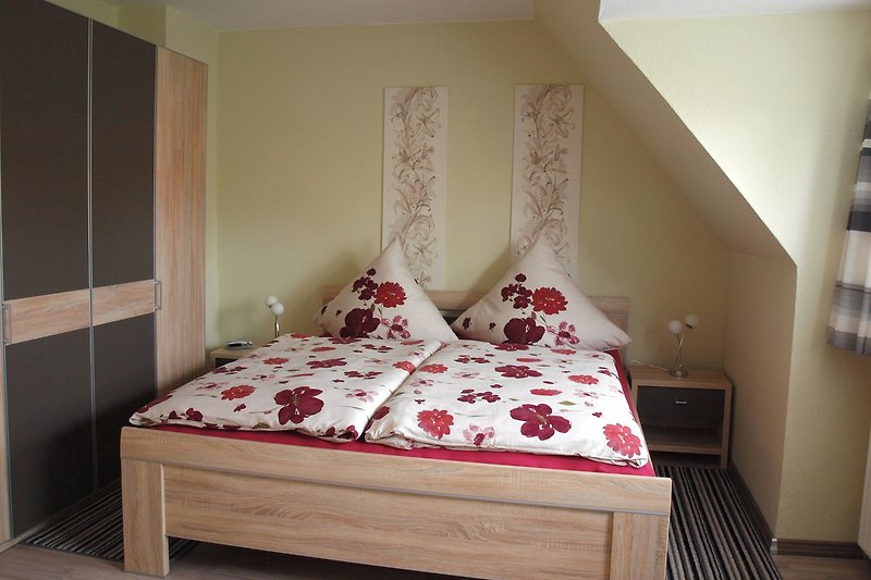 Gemütliches Schlafzimmer mit Holzbett und Kleiderschrank