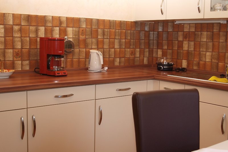 Eine moderne Küche mit Holzschränken und Küchengeräten.