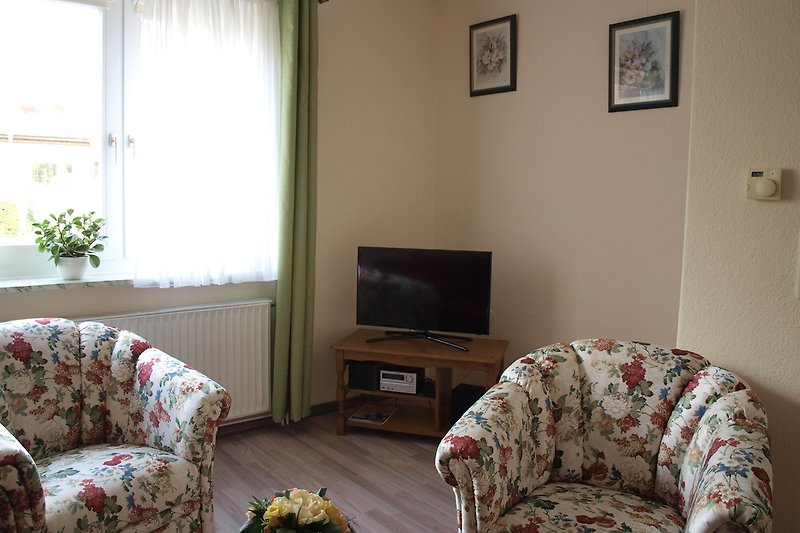 Wohnzimmer mit Sessel, Fernseher und Musik-Anlage