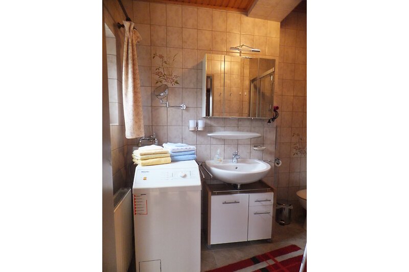 Badezimmer mit elegantem Waschbecken und Spiegel, Waschmaschine