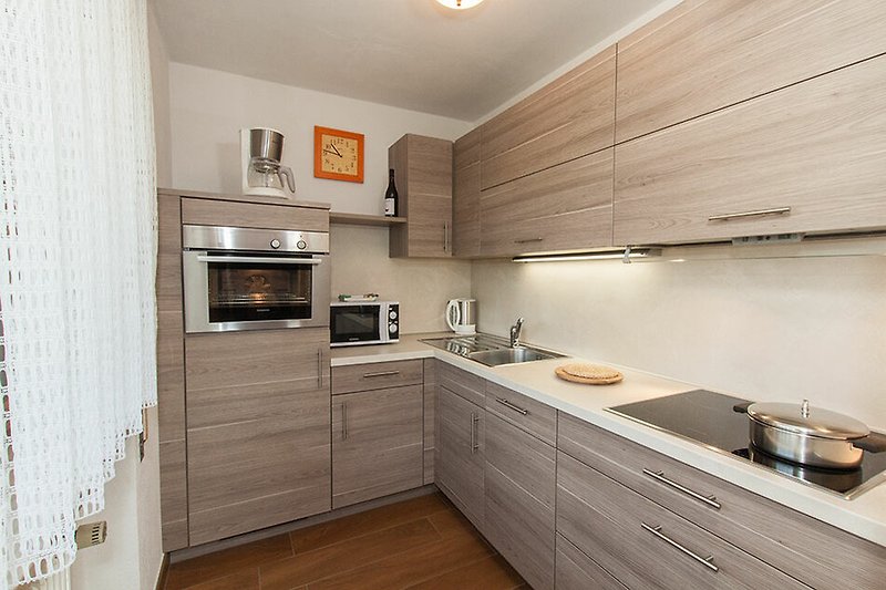 Moderne Küche mit Holzschränken, Granit-Arbeitsplatte und Edelstahlgeräten.