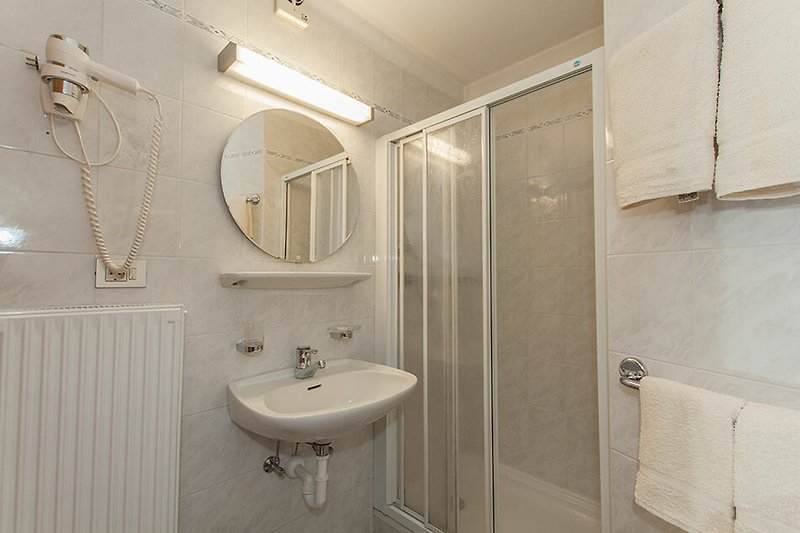 Moderne Badezimmerausstattung mit Spiegel, Waschbecken und Armatur.