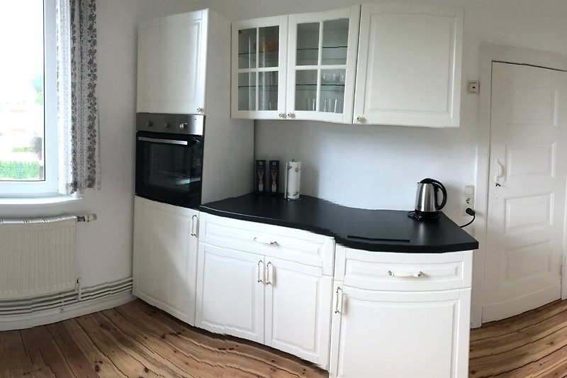 Küche Bild 2 - Küche mit Holzboden, Backofen, Schränken und der rechten Arbeitsplatte