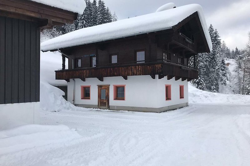 Gemütliches Ferienhaus mit verschneiter Landschaft und malerischem Bergblick.
