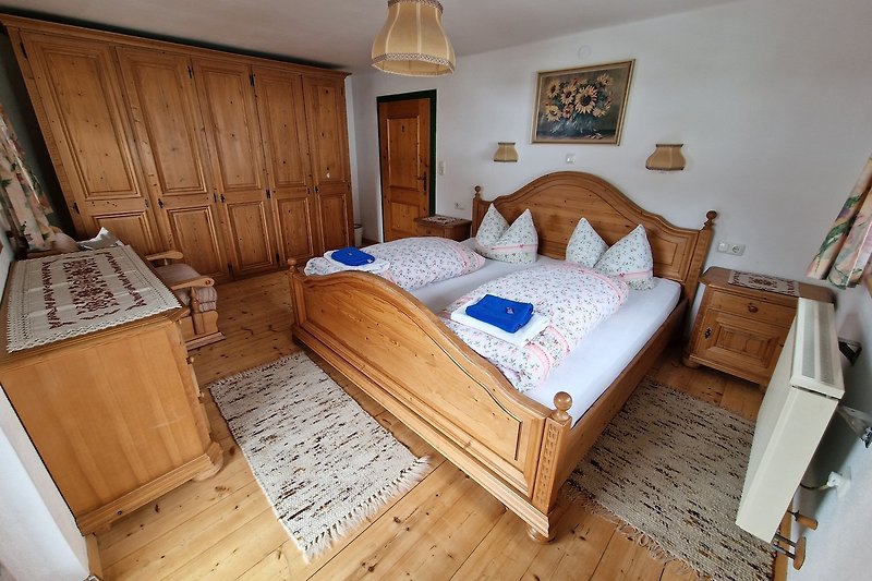 Gemütliches Schlafzimmer mit Holzmöbeln und bequemem Bett - obere Etage.
