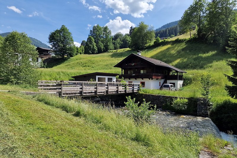 Gemütliches Ferienhaus mit Bergblick und grüner Landschaft.