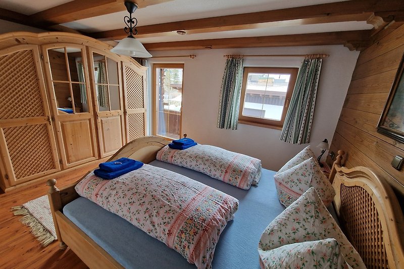 Gemütliches Schlafzimmer mit Holzboden, Fenstern und stilvollem Design.