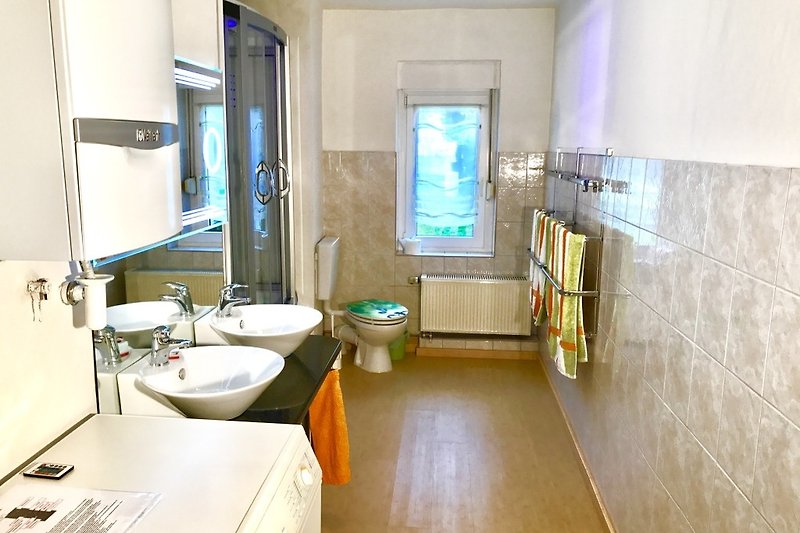 Gemütliches Badezimmer mit Waschmaschine und Spiegel.