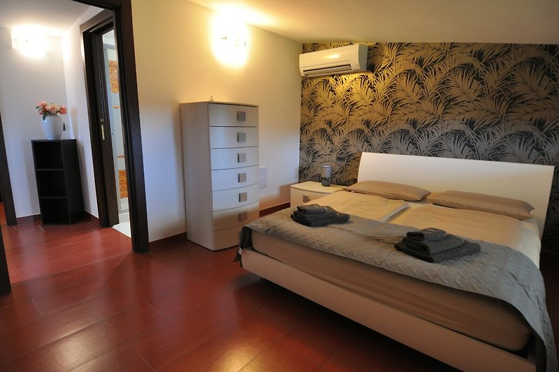 Einladendes Schlafzimmer 1 mit stilvoller Einrichtung und gemütlichem Bett.