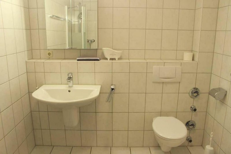 Großes Badezimmer mit Dusche. Sauber und klar.