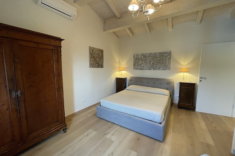 Gemütliches Schlafzimmer mit stilvollen Möbeln und gemütlicher Beleuchtung.