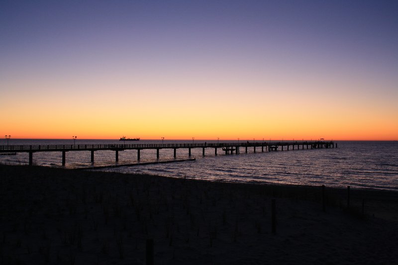 Ein atemberaubender Sonnenuntergang am Meer mit einem malerischen Pier.