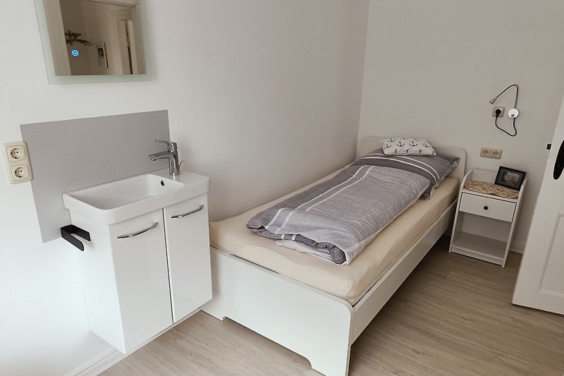 kl.Schlafzimmer mit Holzbett und Waschgelegenheit