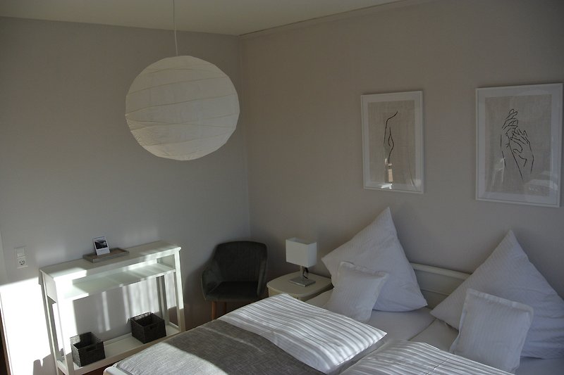 Gemütliches Schlafzimmer mit stilvoller Einrichtung und warmem Licht.