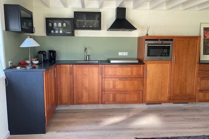 Mooie keuken met houten kasten en moderne apparatuur.
