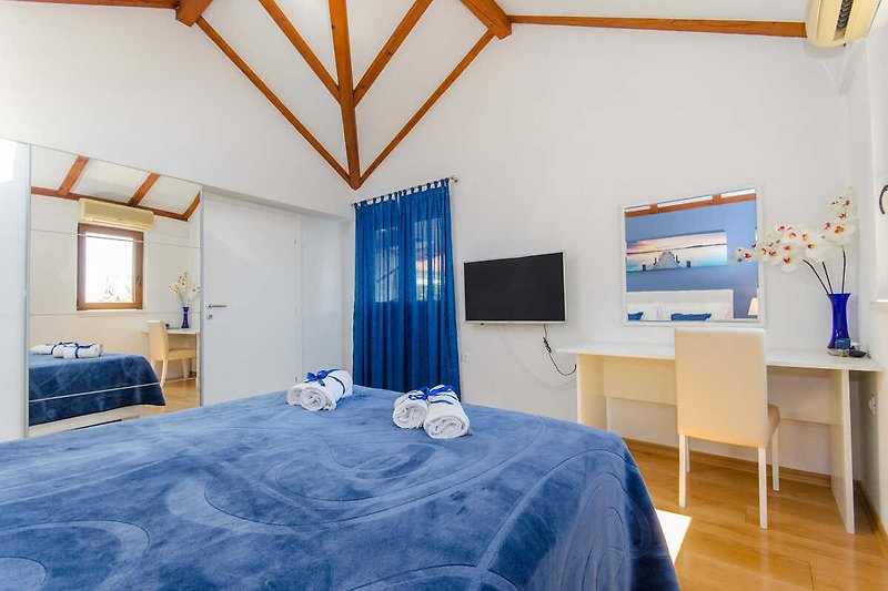 Gemütliches Schlafzimmer mit blauem Bett und stilvoller Dekoration.