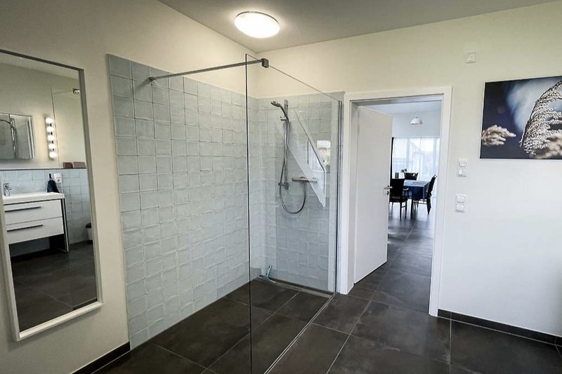 Ein Badezimmer zum Wohlfühlen mit 2 Waschbecken, Schränken, WC und offener Dusche.