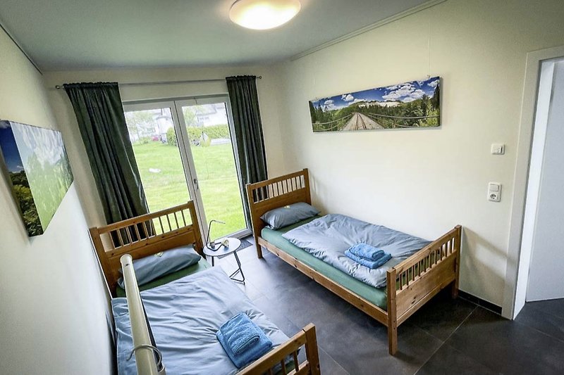 Gemütliches Schlafzimmer mit zwei Einzelbetten und Blick ins "Grüne".