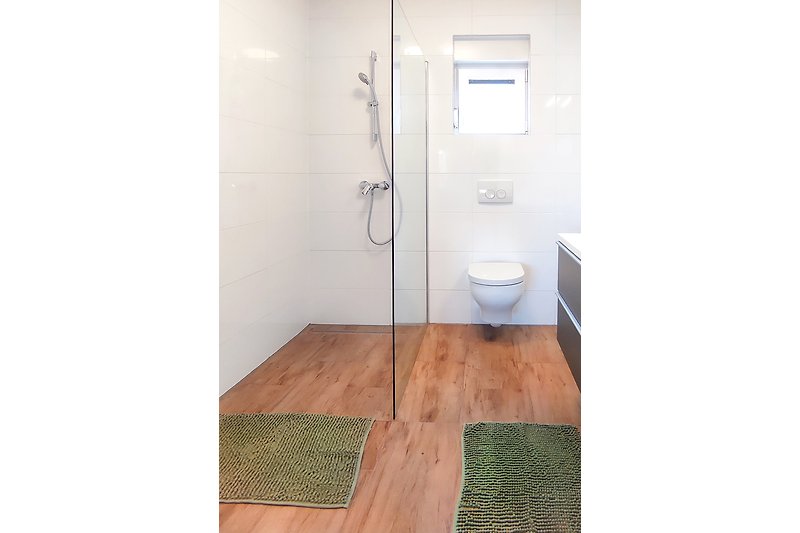 Schönes Badezimmer mit Holzboden und modernen Armaturen.