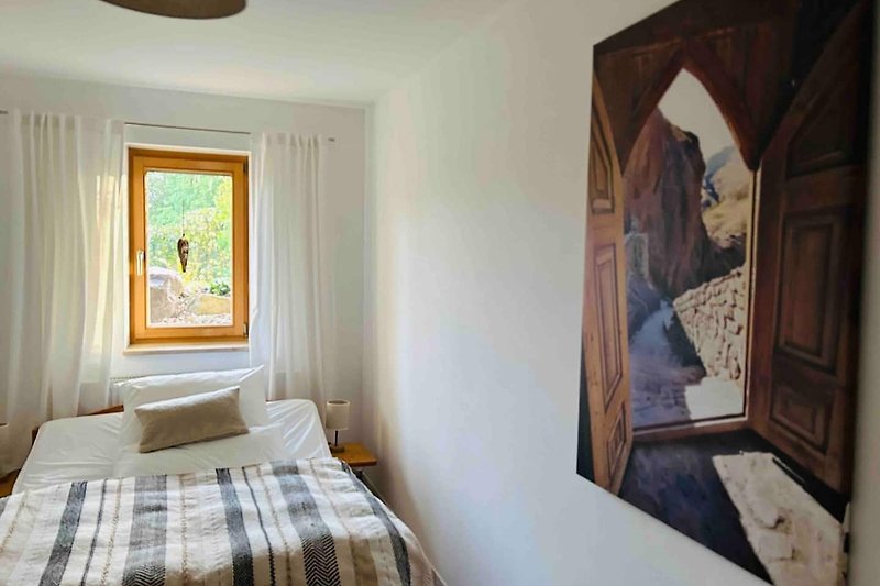 Ein gemütliches Schlafzimmer mit stilvollem Holzbett und schöner Fensterdekoration.