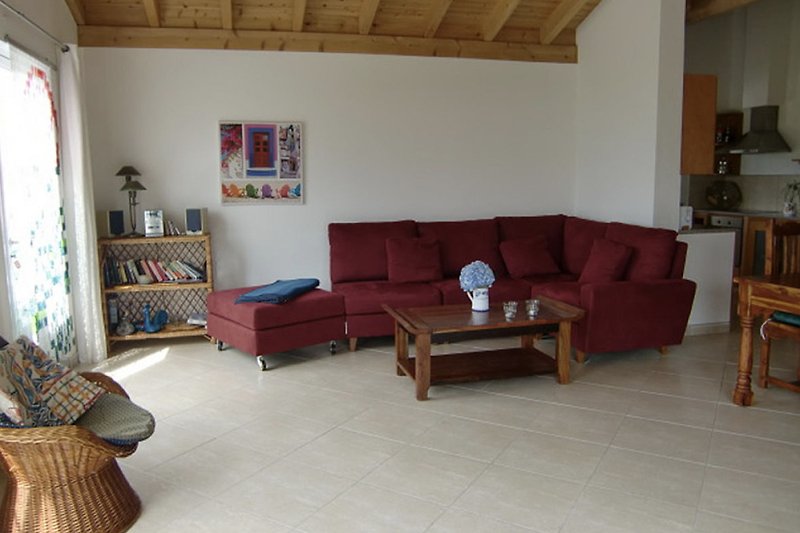 Komfortables Wohnzimmer mit Holzmöbeln und gemütlicher Couch.