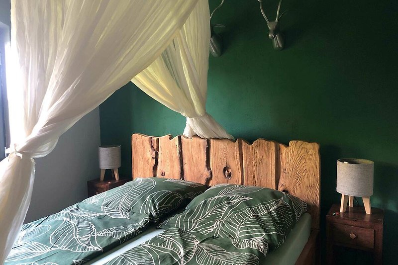 Gemütliches Schlafzimmer mit handgeschnitztem Holzbett (160x210 cm)