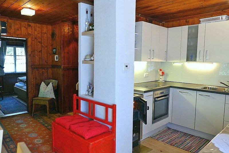 Gemütliche Küche mit Holzmöbeln, moderner Ausstattung und schönem Fensterblick.