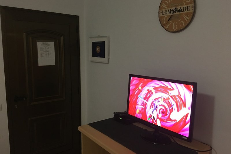 Un moderno salotto con  televisione  a schermo piatto.
