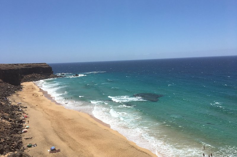 Una vista mozzafiato sull'oceano, con spiaggia di sabbia bianca e onde che si infrangono sulla costa.